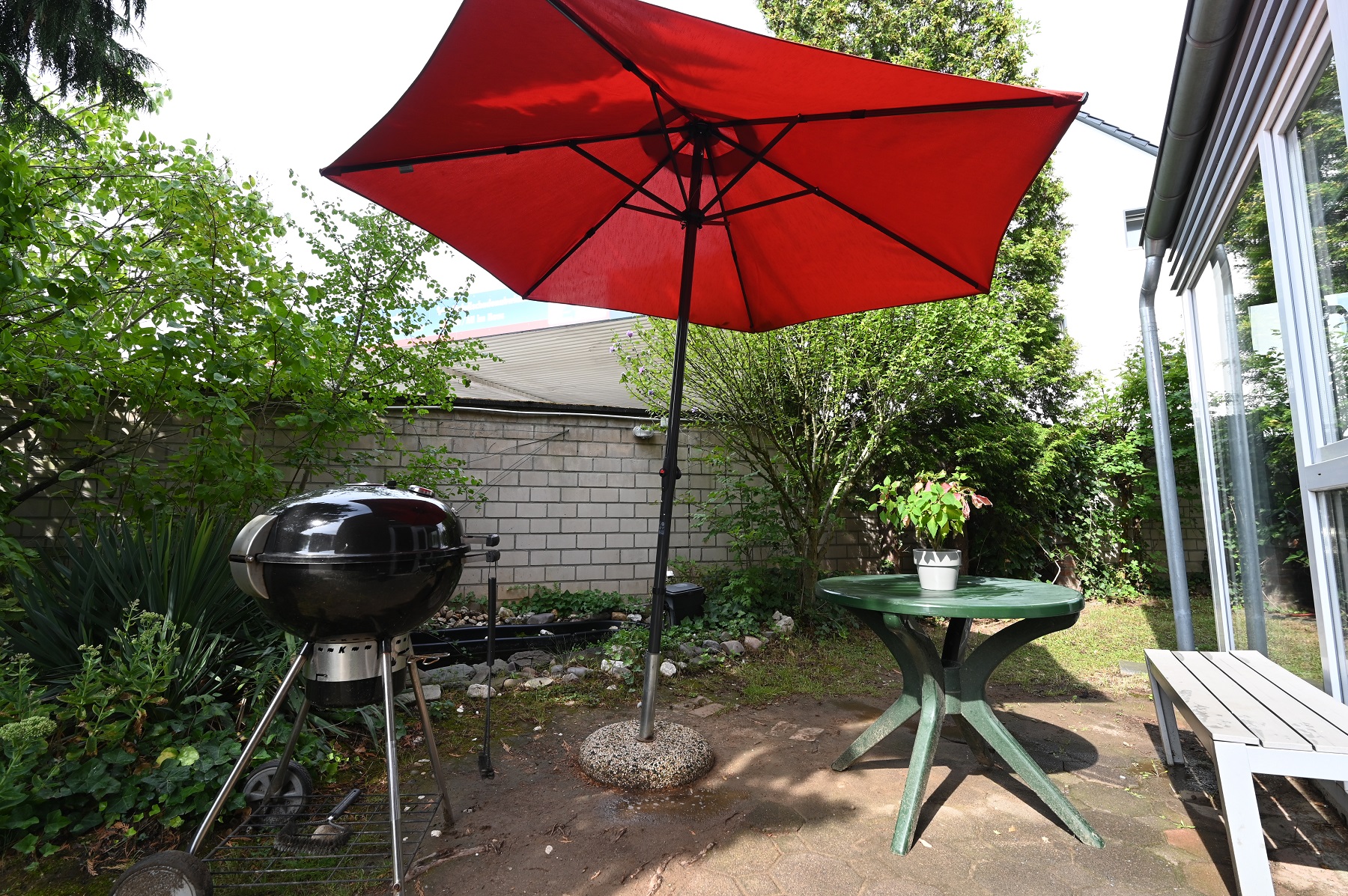 Roter Sonnenschirm und Grill im Garten Haus Kölner Straße in Porz